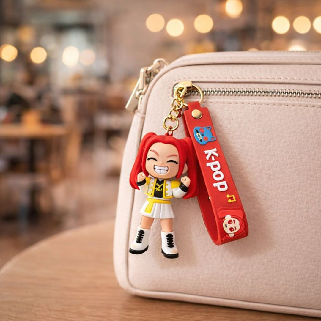 Keychain with a character and 'KPOP' strap attached to a beige bag in a blurred indoor setting.