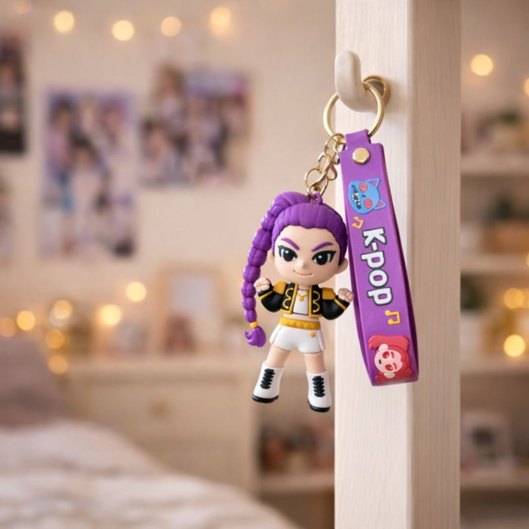Keychain with a character and 'KPop' tag hanging on a hook in a room.

