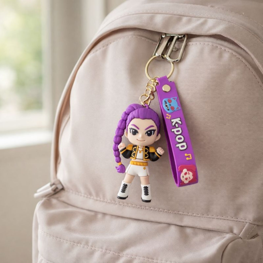 Keychain with a character rumi and 'KPOP' strap attached to a beige backpack.

