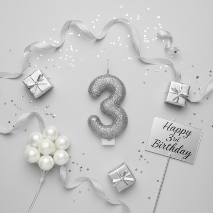 Silver glitter number 3 candle flat lay with silver ribbons gift boxes and silver party decor